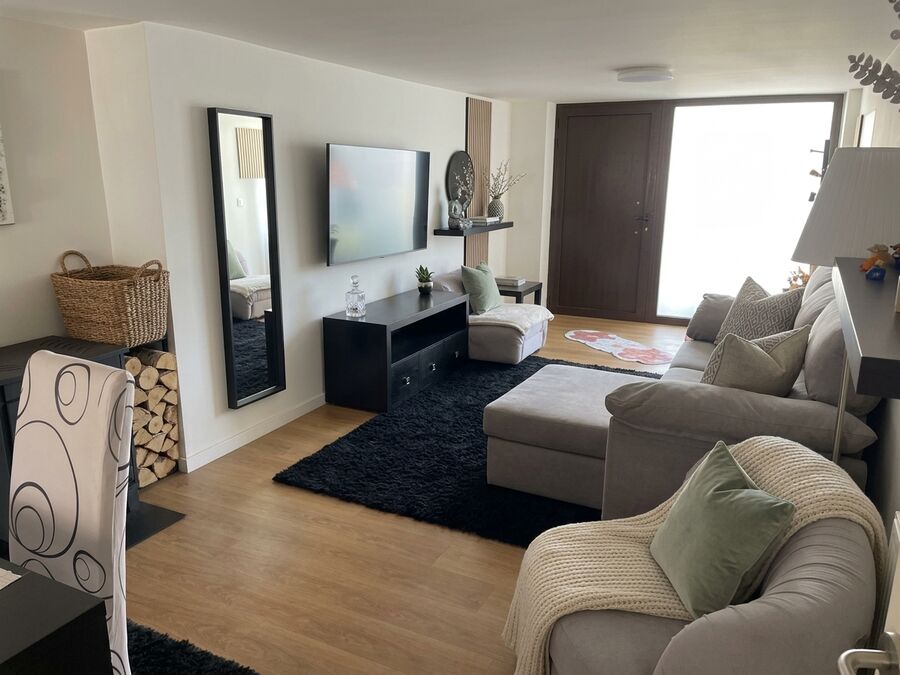 Sala de estar ampla com sofá e TV do apartamento de férias em Ofir